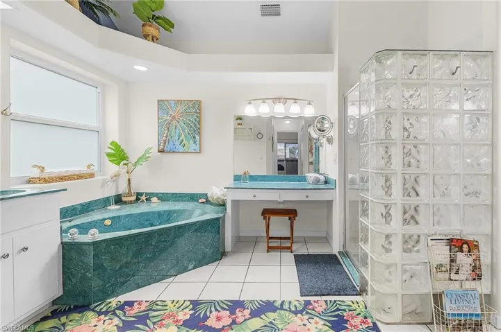 Bathroom with vanity, a stall shower, a garden tub, and tile patterned floors