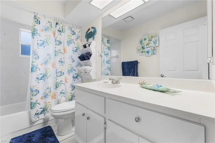Bathroom featuring vanity, toilet, and shower / bath combo with shower curtain