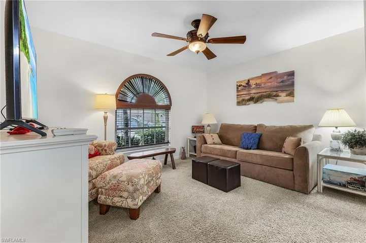 Living area with a ceiling fan and carpet