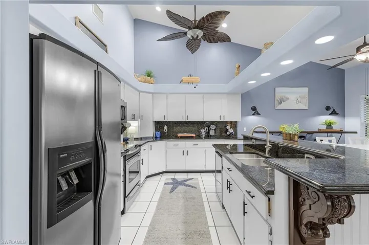 Kitchen with stainless steel appliances, ceiling fan, light tile patterned floors, decorative backsplash, and recessed lighting