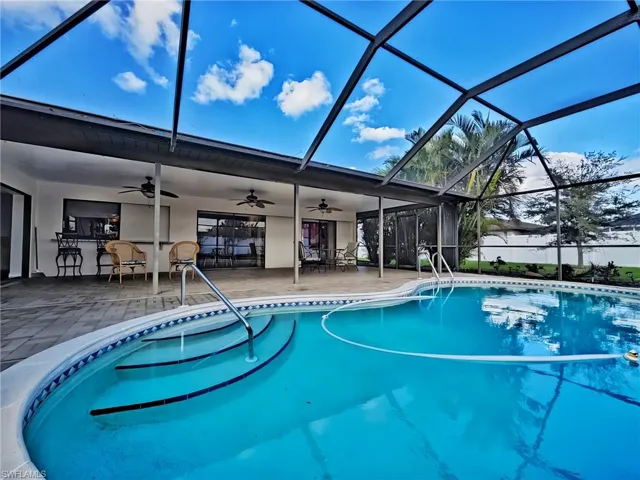 View of pool with a bar and a patio