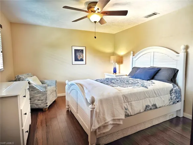 Bedroom with ceiling fan and dark hardwood / wood-style flooring