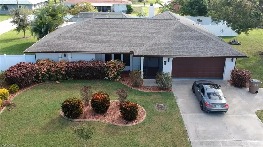 Ranch-style home with a garage and a front lawn