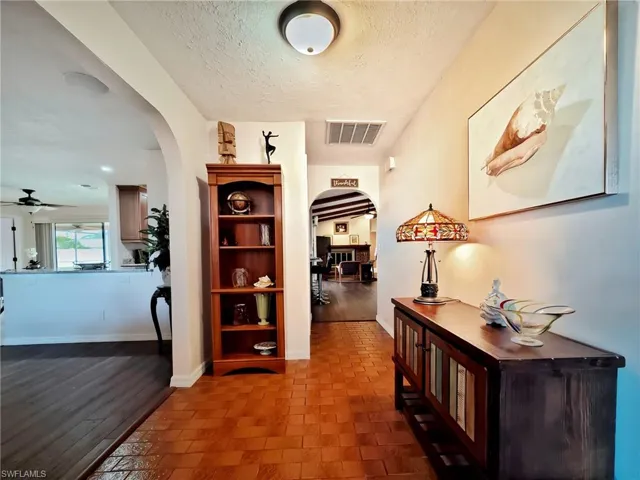 Corridor with dark hardwood / wood-style flooring and a textured ceiling