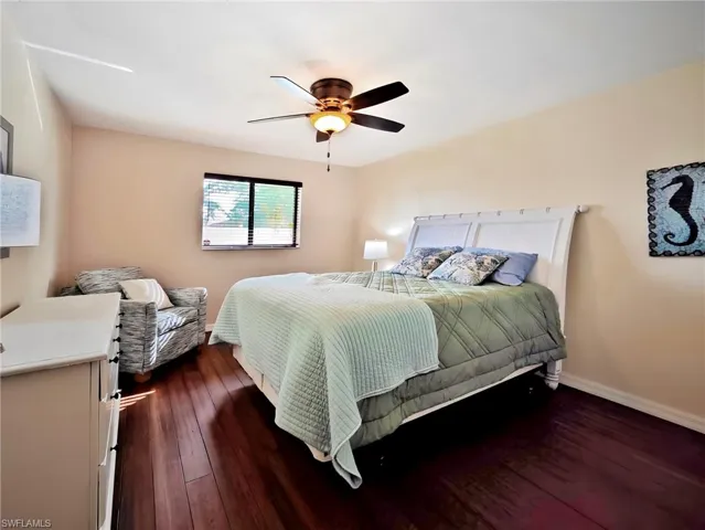 Bedroom with ceiling fan and dark wood-type flooring
