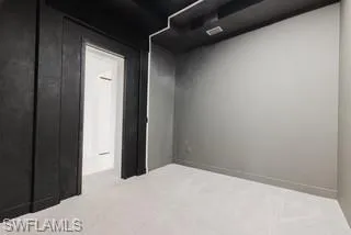 Spare room with light carpet and baseboards