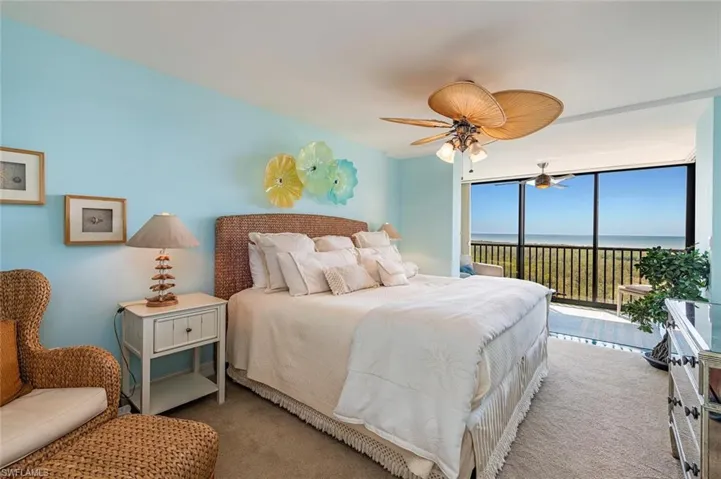 Carpeted bedroom with a water view, access to outside, a wall of windows, and ceiling fan