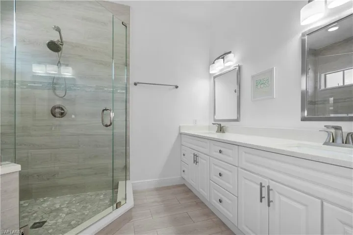 Master's bathroom with double vanity and a shower stall