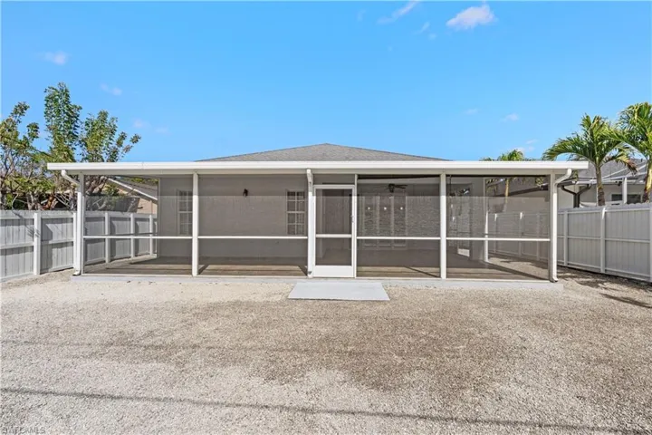 Rear view of house with a fenced backyard