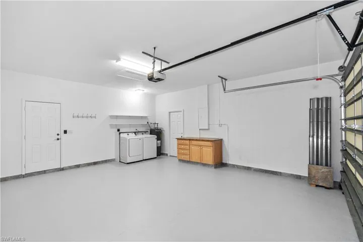 Garage with electric water heater, washer and dryer, and a garage door opener