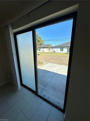 Doorway to outside with a residential view and tile patterned floors