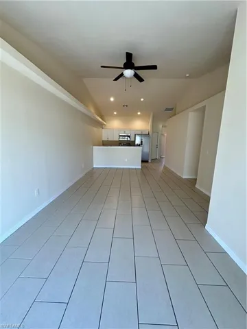 Unfurnished living room featuring lofted ceiling, a ceiling fan, recessed lighting, and light tile patterned floors
