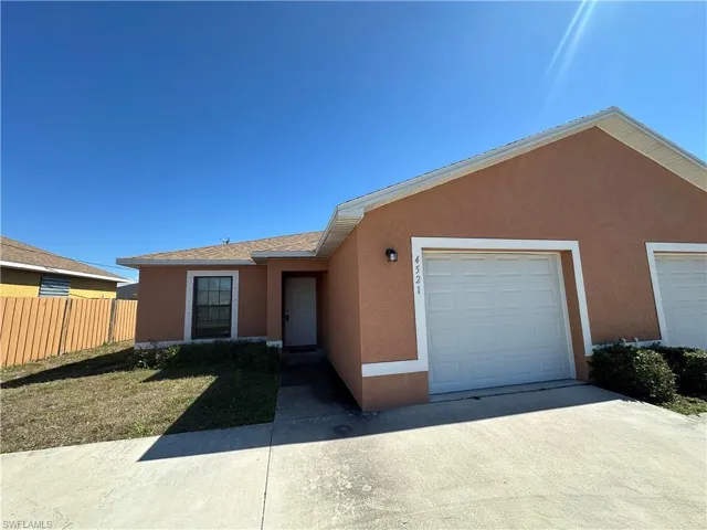 Single story home featuring stucco siding, a garage, and concrete driveway