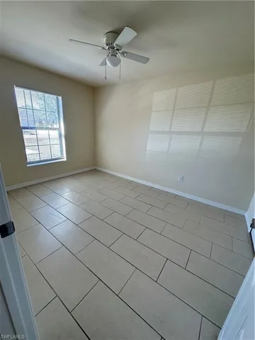 Spare room featuring ceiling fan and light tile patterned flooring