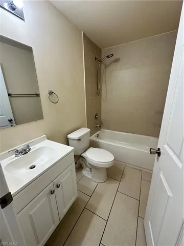 Full bath featuring vanity, shower / bathtub combination, and light tile patterned floors