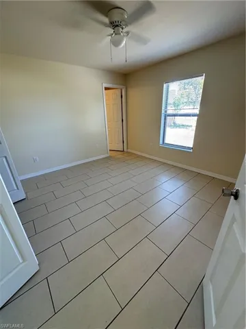 Unfurnished room with a ceiling fan and light tile patterned flooring