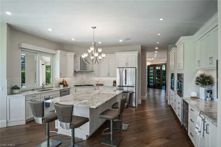 CHEF’S KITCHEN features beautiful white cabinetry, premium appliances including a THERMADOR gas cooktop & BOSCH stainless steel appliances with side-by-side ovens, CRISTALLO countertops, soft-close cabinetry and drawers, and a spacious layout!