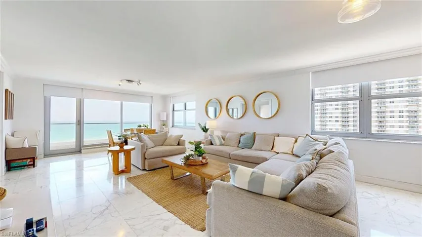 Living area featuring light marble finish floors and ornamental molding