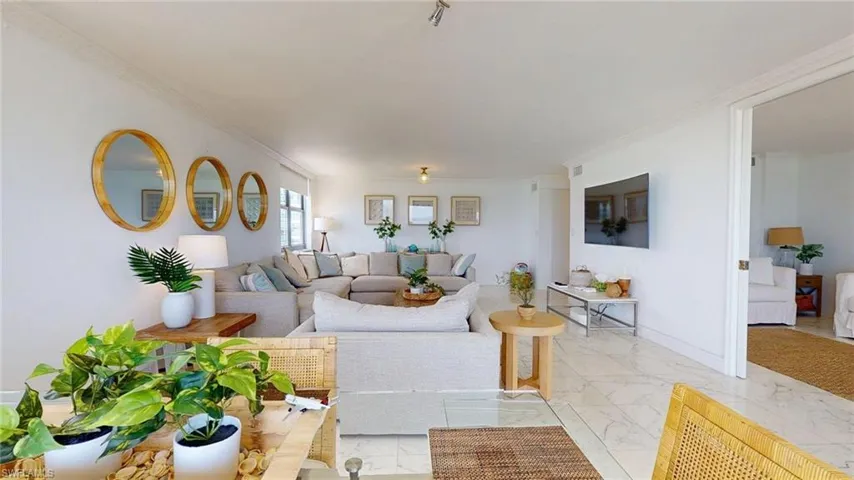 Living area featuring light marble finish floors and ornamental molding