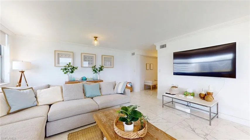 Living room featuring marble finish floors and crown molding
