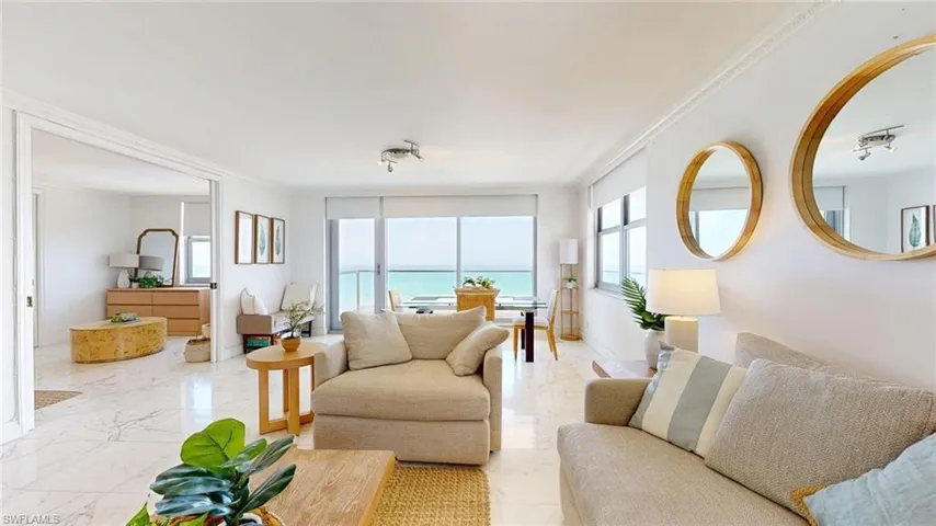 Living room featuring crown molding, a water view, and marble finish floors