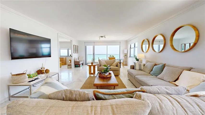 Living room with crown molding, plenty of natural light, and marble finish floors