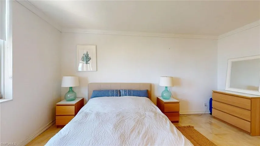 Bedroom featuring crown molding and baseboards