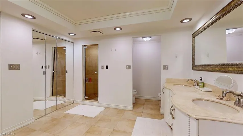 Bathroom with recessed lighting, double vanity, a shower stall, light tile patterned flooring, and crown molding