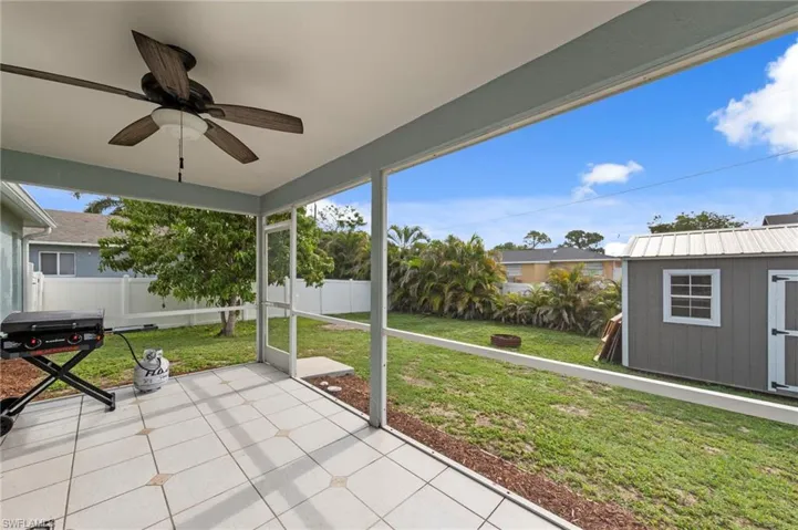 Screened patio featuring tile flooring and a ceiling fan