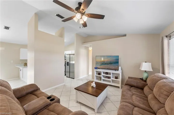 Spacious living area featuring neutral paint tones and tile flooring