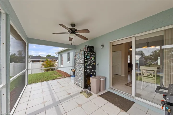 Screened patio featuring tile flooring and a ceiling fan