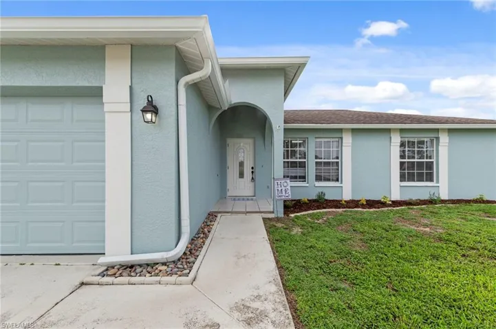 Single-story residence featuring a light blue stucco exterior and a white trim