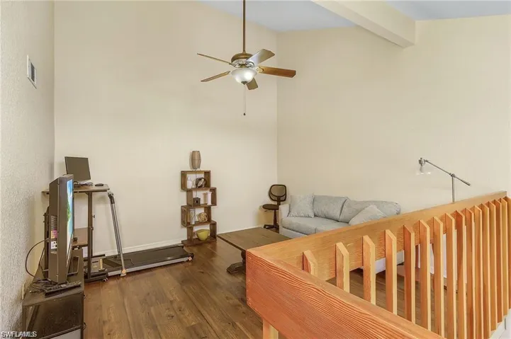 Loft featuring wood finished floors, lofted ceiling with beams, a ceiling fan, and visible vents