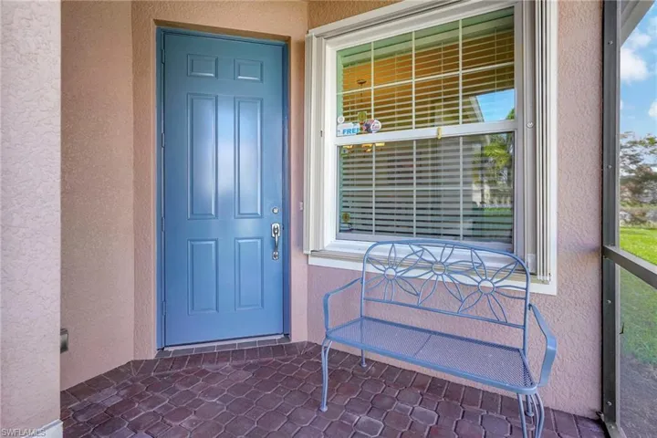 View of exterior entry with stucco siding and covered porch