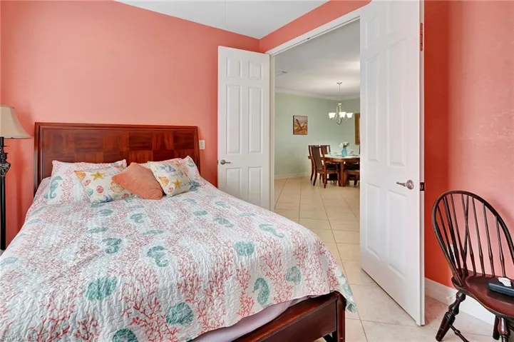 Laundry area featuring washing machine and dryer, crown molding, cabinet space, and light tile patterned floors