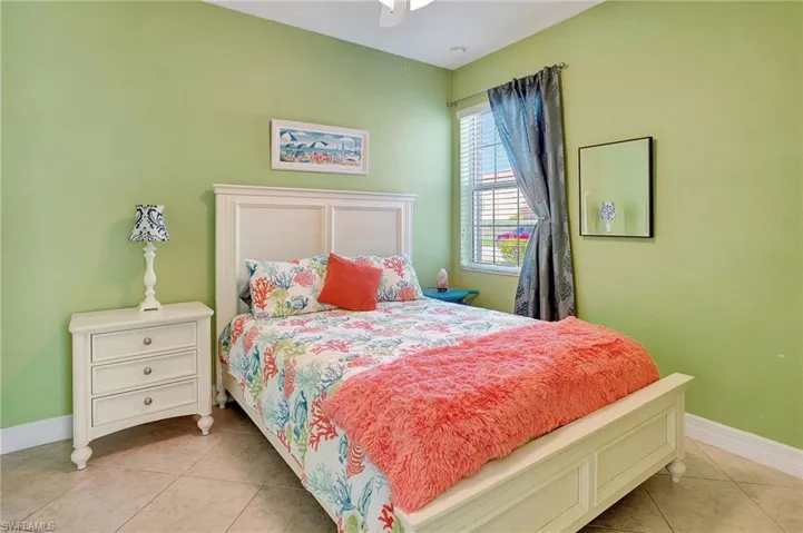 Bedroom with a closet, light tile patterned flooring, and a ceiling fan
