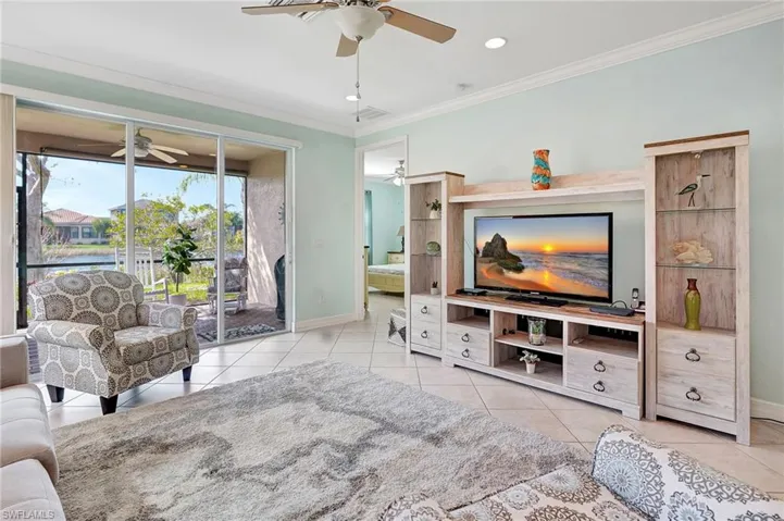 Living area with crown molding, light tile patterned floors, recessed lighting, and ceiling fan