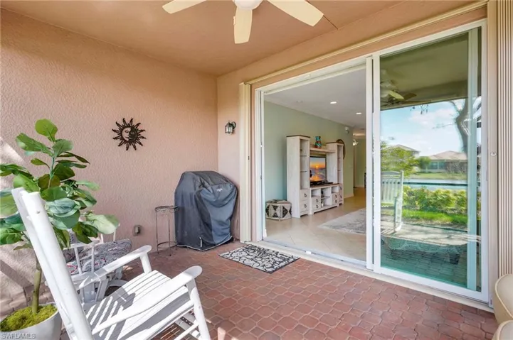 Back of property featuring stucco siding, a tile roof, a sunroom, and a lawn