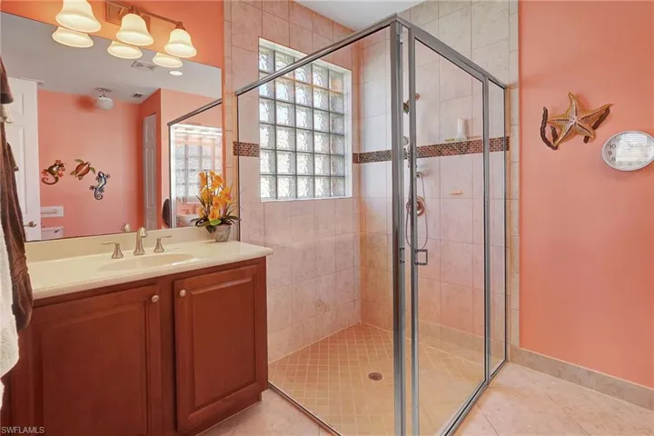 Bathroom with a stall shower, vanity, and tile patterned flooring