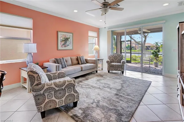 Living room featuring crown molding, tile patterned flooring, and recessed lighting