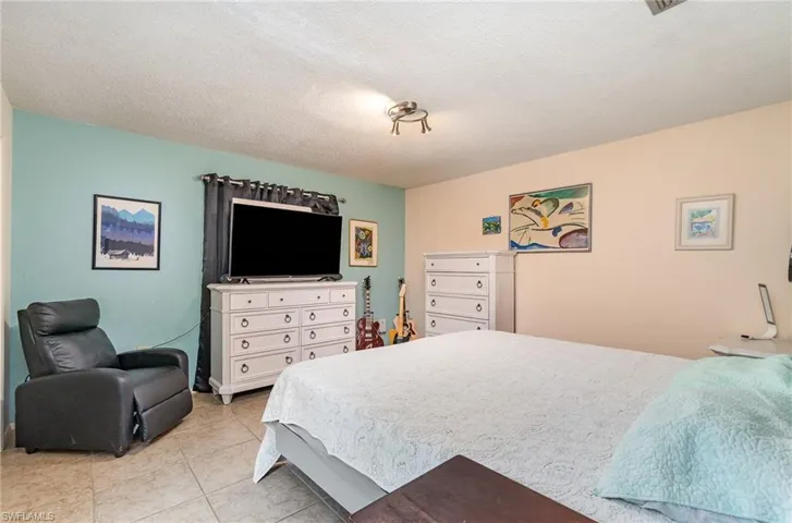 Tiled bedroom with a textured ceiling