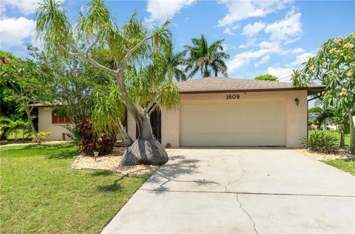 View of front of house with a front yard and a garage