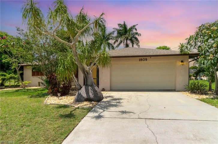 View of front of house featuring a garage and a lawn