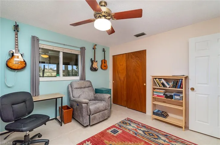 Bedroom featuring tile flooring, ceiling fan, and a textured ceiling