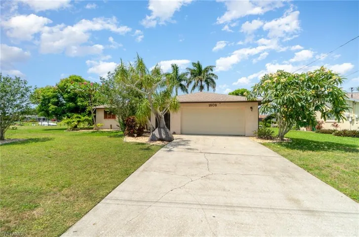 View of front of property featuring a garage and a front yard