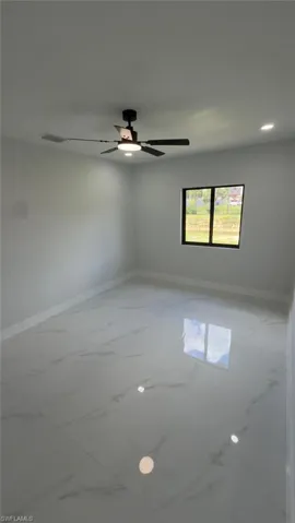 White large format tile flooring, contemporary ceiling fan, recessed lighting, and a dark-framed window