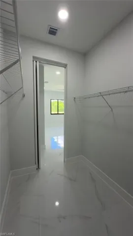 Walk-in closet featuring wire shelving, recessed lighting, and tile flooring