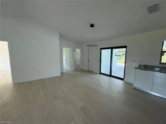 Unfurnished dining area with vaulted ceiling and light wood finished floors