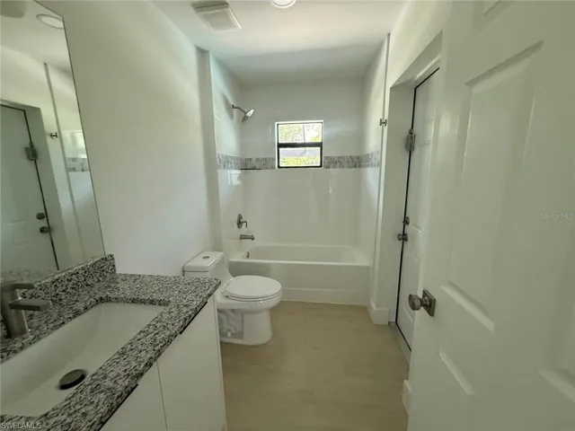 Full bath with vanity, shower / washtub combination, and light wood-type flooring