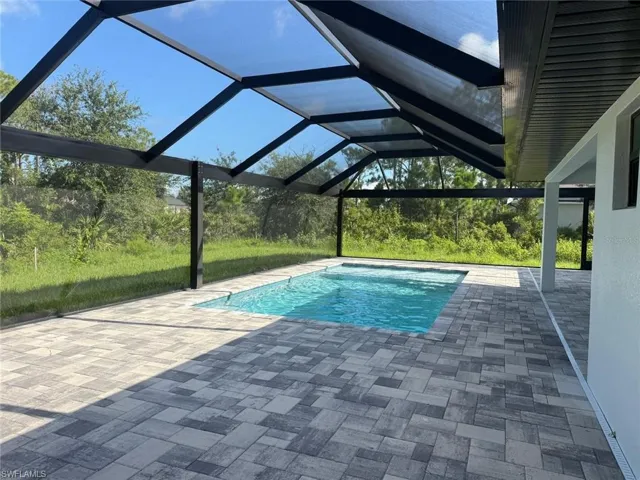 Swimming pool featuring a lanai, a patio, and a sunroom